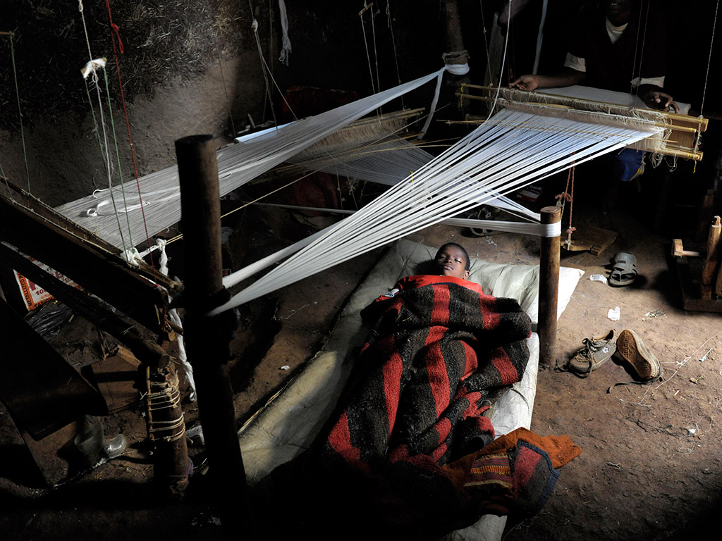 Israel, 9, sover på en tunn madrass på lergolvet.